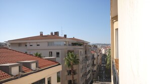 A multi-story building with a red-tiled roof, balconies, and a palm tree. - Cosy studio in Cannes (Cannes)