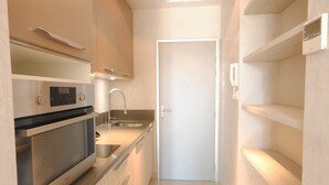 A compact kitchen with a microwave, oven, and sink. - Cosy studio in Cannes (Cannes)