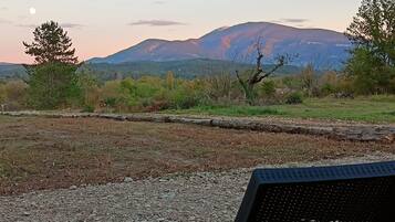 A gravel area with a chair and a view of a mountain range.