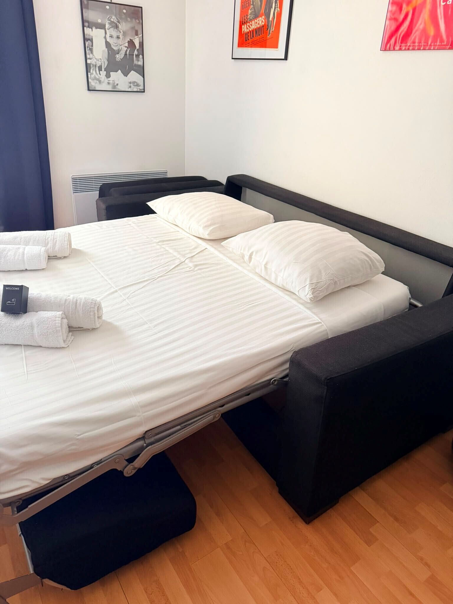 A single bed with a mattress, pillows, and a folded towel.