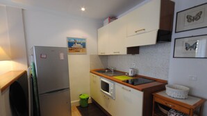 A compact kitchen with a refrigerator, microwave, sink, and wooden countertop. - Palais Rouaze/ Beg4012/ 2P (Cannes)
