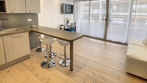 Una cocina moderna con barra, mesa de comedor y sofá.