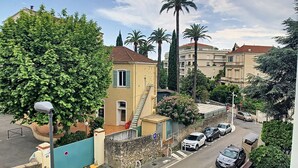 A street view with parked cars, a pedestrian crossing, and buildings with balconies. - WINDSOR/DET2002-1/bed (Cannes)