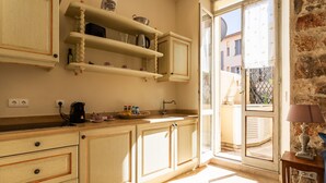 Una cocina con armarios de madera, una encimera y una ventana con vistas a edificios.