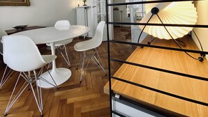 A dining area with a white table, white chairs, a wooden floor, and a ceiling fan. - Riviera Design / Charming apartment 2mn from the beach (Cannes)