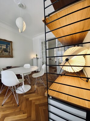 A dining area with a white table, white chairs, a wooden floor, and a ceiling fan. - Riviera Design / Charming apartment 2mn from the beach (Cannes)