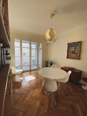 A dining area with a round table, white chairs, a ceiling fan, and a painting on the wall. - Riviera Design / Charming apartment 2mn from the beach (Cannes)