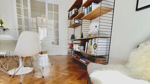 A modern living room with a herringbone wooden floor, a white sofa, a white chair, a bookshelf, and a lamp. - Riviera Design / Charming apartment 2mn from the beach (Cannes)