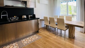 Una cocina moderna con comedor, suelo de madera y vistas a través de una ventana.