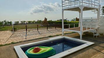 Relax by the pool surrounded by a serene lawn and natural rock formation.