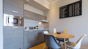 Eine moderne Küche mit eingebauter Mikrowelle, einem Edelstahlbackofen und einer digitalen Anzeigetafel an der Wand.