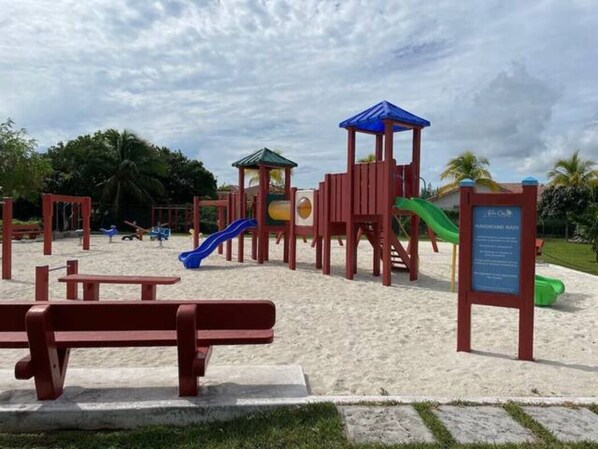 A playground with slides and climbing structures, a picnic table, and a signboard. - Palm Cay Marina, Resort & Spa (Nassau)