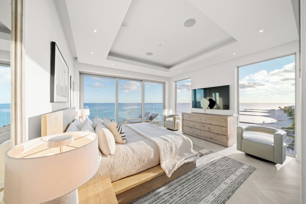 Een moderne slaapkamer met een groot bed, een televisie en uitzicht op de oceaan.