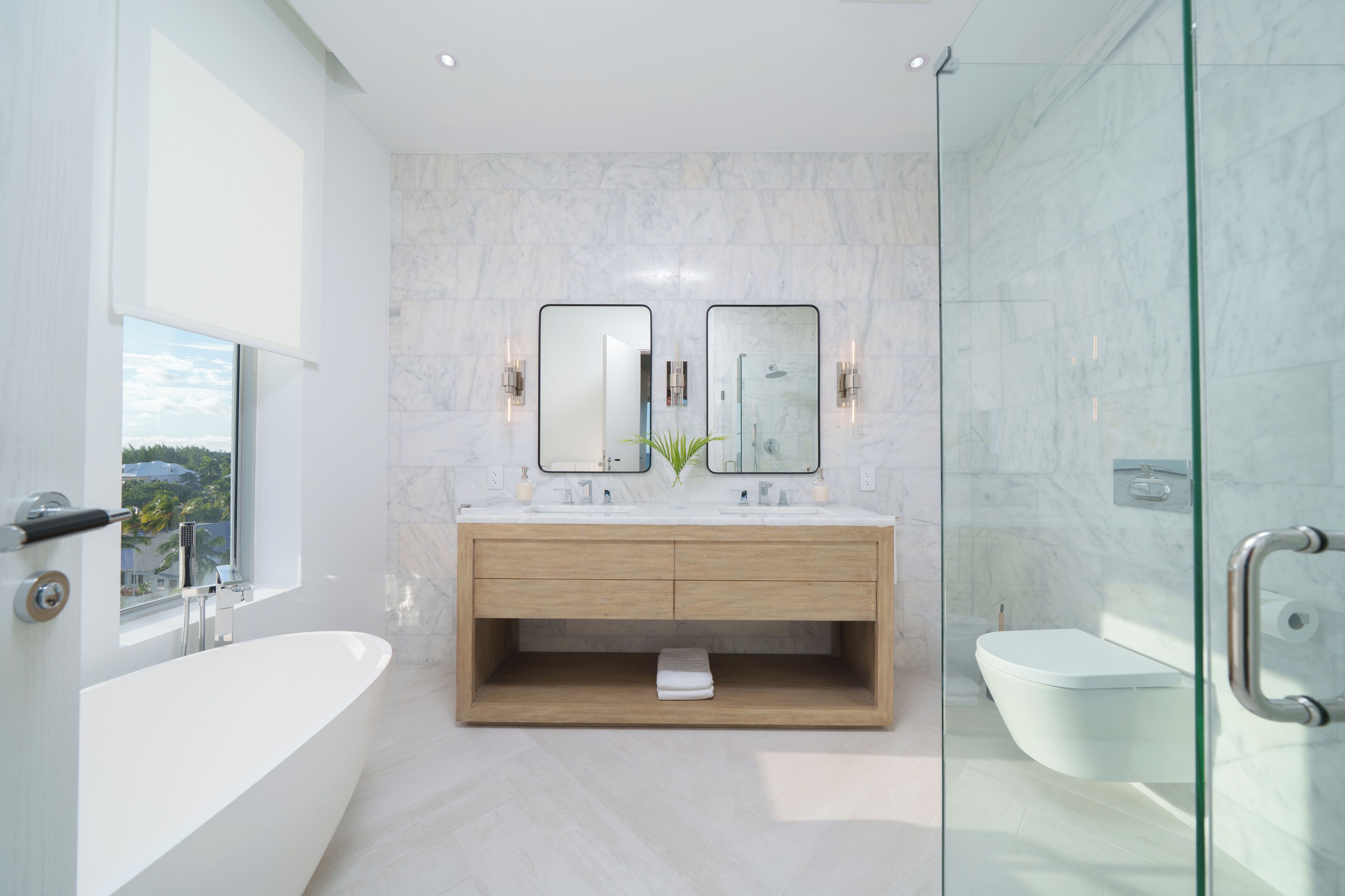 Un baño moderno con una bañera grande, un lavamanos doble y un box de ducha de vidrio.