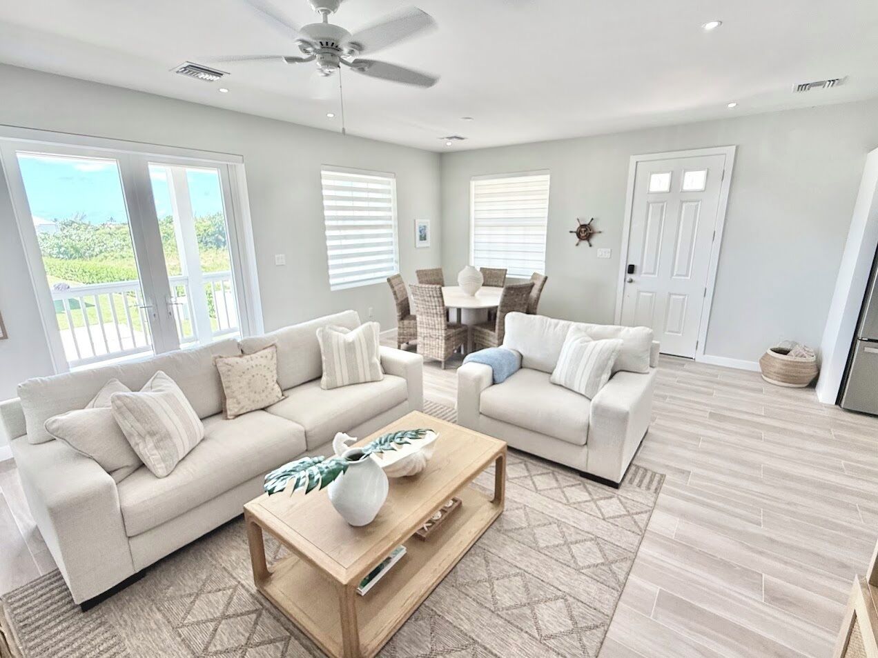 A spacious living room with two sofas, a coffee table, and a ceiling fan.
