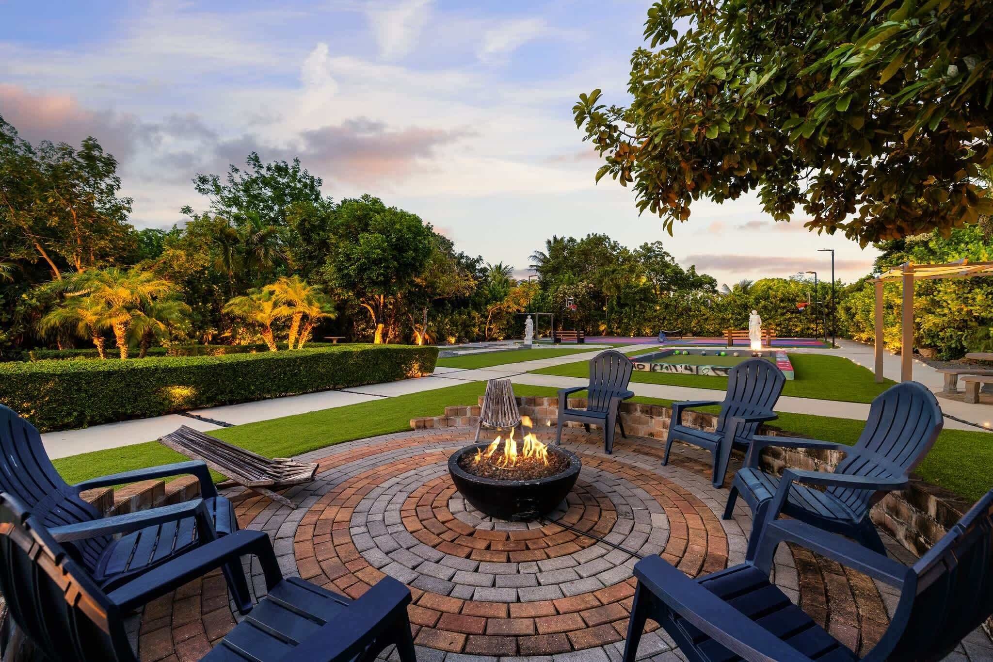 An outdoor patio with a fire pit, seating, and a well-maintained garden.