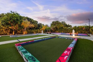 A well-maintained outdoor area with a green artificial turf, a basketball court, and a statue. - Swish Villa | Unique BKB Court | Outdoor Cinema (Miami)