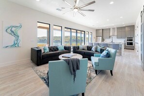 Ein modernes Wohnzimmer mit einer Eckcouch, einem Couchtisch und Blick zur Küche.