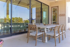 Un comedor con mesa y sillas, ventanas amplias y vistas al exterior.