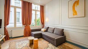 Una sala de estar moderna con un sofá modular, una mesa de centro redonda y una alfombra estampada.