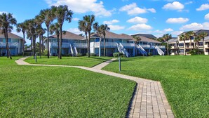 A resort with multiple-story buildings, palm trees, and a well-maintained lawn. - Oceanfront, stunning, renovated, Guests love it! (Ponte Vedra Beach)