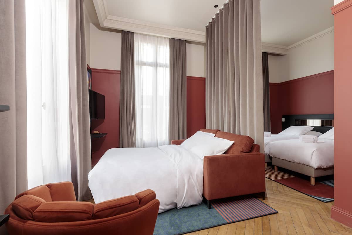 Ein Hotelzimmer mit Bett, Sofa und Fernseher.
