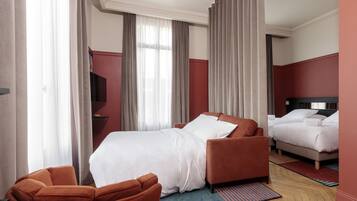 A hotel room with a bed, a sofa, and a TV.