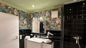 Une salle de bain moderne avec un meuble-lavabo à deux vasques, un grand miroir et un espace douche.