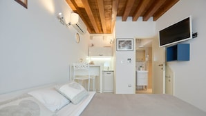 Een slaapkamer met een bed, een bureau en een televisie.