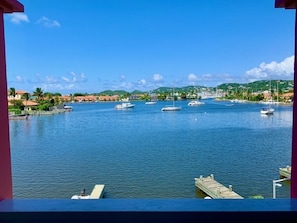 Uma marina com vários barcos atracados, céu azul claro e vista da paisagem ao redor.