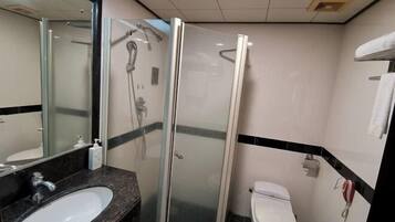 Un baño con ducha de vidrio, un lavabo blanco y un inodoro.