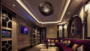 A luxurious lobby with a curved purple sofa, a large TV screen, and a decorative ceiling. - Tianma Hotel (Shantou)