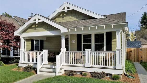 A single-story house with a front porch, a chimney, and a number '48' on the front wall.