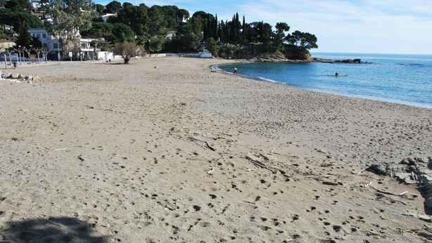 A sandy beach with footprints, a clear sky, and buildings in the background. - Charming, renovated house—4-minute walk to Grifeu Beach—Beautiful garden—Parking—Air conditioning (Llançà)