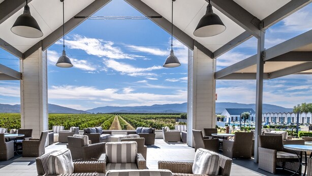 An outdoor seating area with wicker furniture and pendant lighting, overlooking a vineyard and mountains. - 25% Off Sept WkDay, Near Wineries -Private Jacuzzi (Temecula)