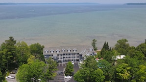 A building with a parking lot and a view of the sea. - Stunning Views, Private Master Suite - North Shore Inn Condo 306 (Traverse City)