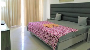 Una camera da letto con un letto, un comodino, una testiera grigia e un quadro appeso al muro.
