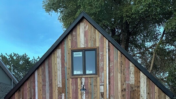 A rustic wooden building with two garage doors and a small window. - Adorable Brand New Studio Barn Loft with Full Kitchen and Bath (Provo)
