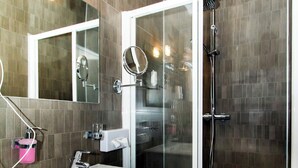 Une salle de bain moderne avec un meuble-lavabo blanc, une douche à parois de verre et un miroir au-dessus du lavabo.