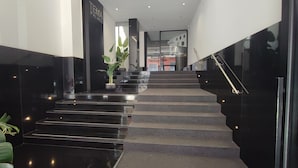 A modern hotel lobby with a staircase, a reception desk, and a sign reading 'TEMA PALACE'. - Via Niccolò Tommaseo 4 - appartamento 2 (Napoli)