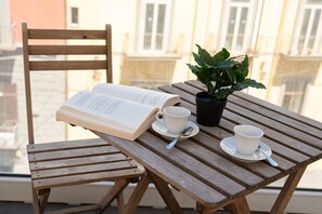 A wooden table with a book, two cups, a saucer, and a potted plant. - Via Niccolò Tommaseo 4 - appartamento 2 (Napoli)
