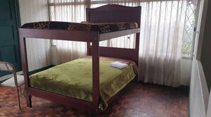Cozy retreat with a single bed, wooden floor, and a comfortable chair.