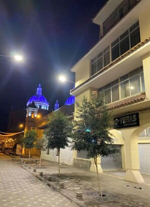 Vitas building stands out with its distinctive blue dome, situated on a quiet street lined with trees.