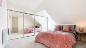 A bedroom with a large bed, a sliding glass door leading to another room, and a skylight. - The Penthouse, Beautiful sea views, Centre of Oban (Oban)