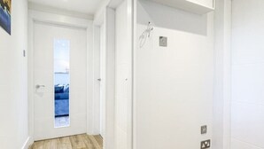 A hallway with wooden flooring, white walls, and a door with a view of the sea. - The Penthouse, Beautiful sea views, Centre of Oban (Oban)