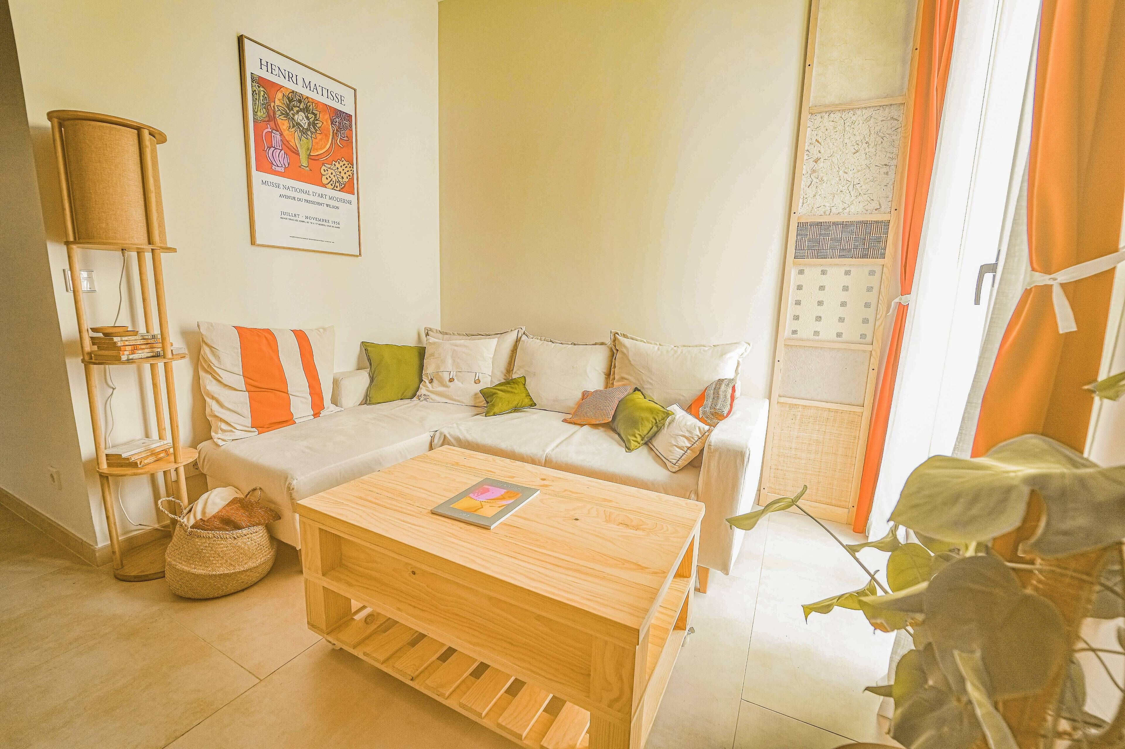 Una sala de estar acogedora con un sofá, una mesa de centro de madera y una estantería.