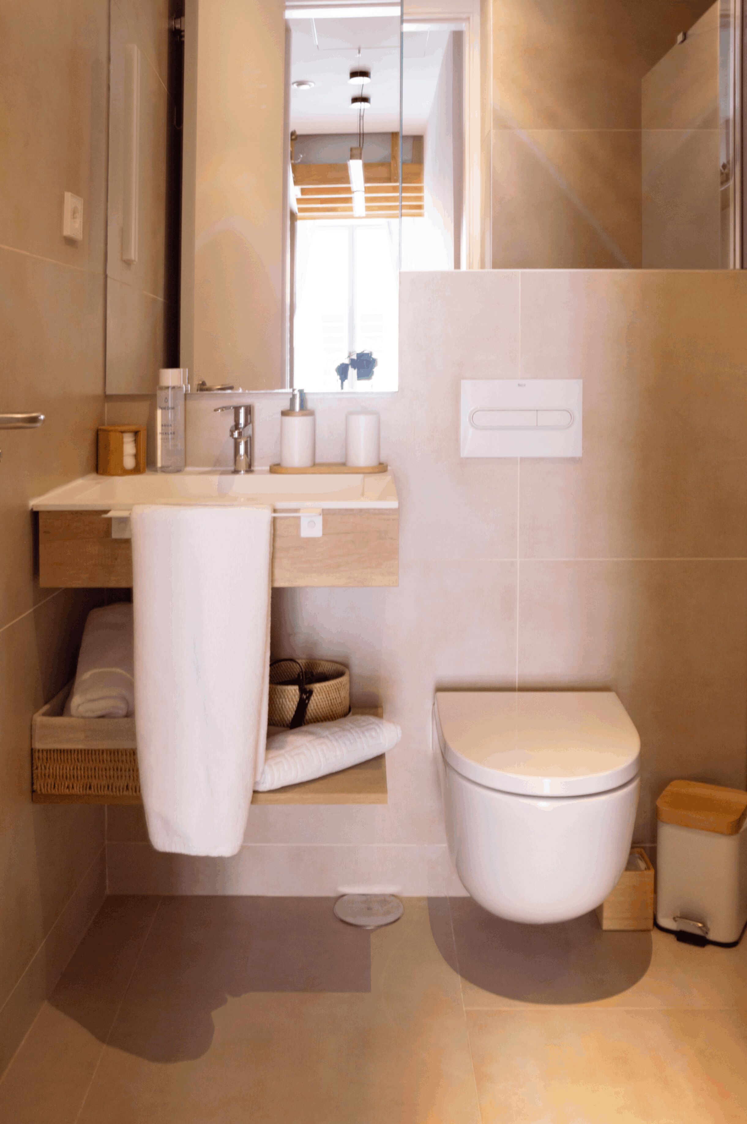 Une salle de bain moderne avec des toilettes, un lavabo et un miroir.
