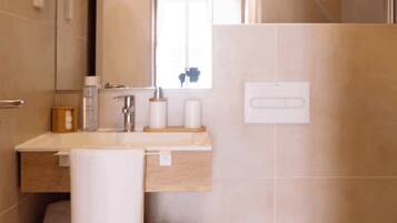 Une salle de bain moderne avec des toilettes, un lavabo et un miroir.