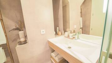 Un baño moderno con un espejo grande, un lavabo blanco y un mueble de tocador de madera.