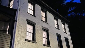 A multi-story building with large windows and a visible metal structure above. - Historic house overlooking Rondout Creek (Kingston)